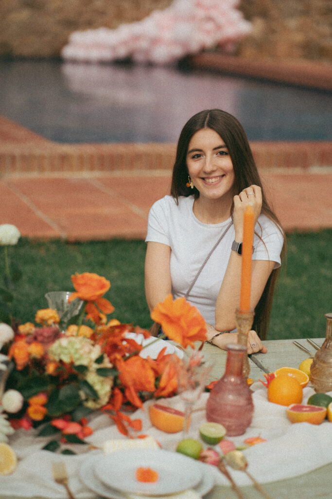 Cris de Pasito Blanco junto a una mesa de picnic decorada en tonos naranjas