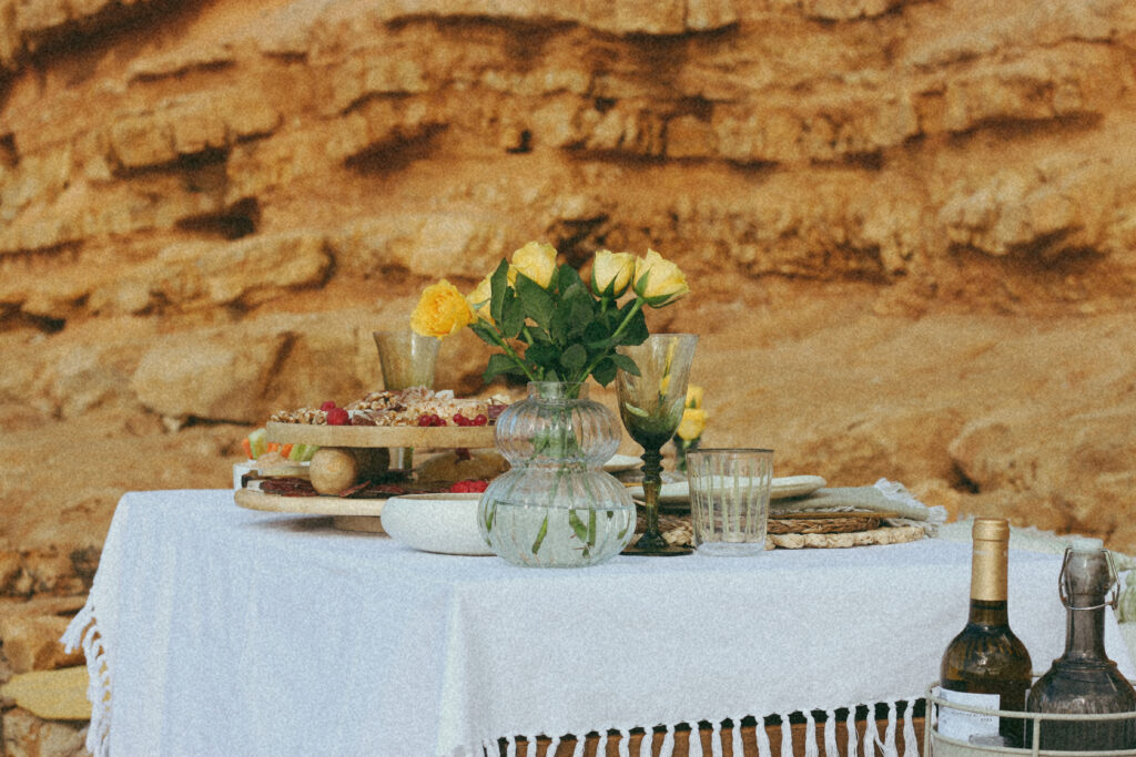 Mesa decorada con jarrón de flores y tabla de comida